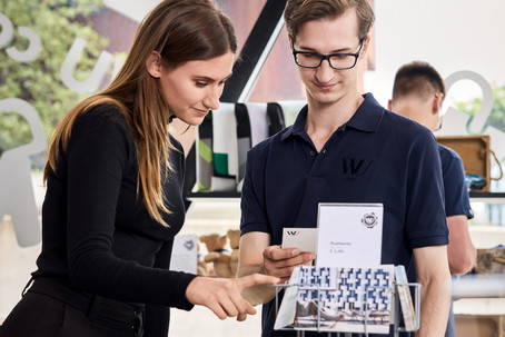 A man and a woman look at postcards in the WU Shop